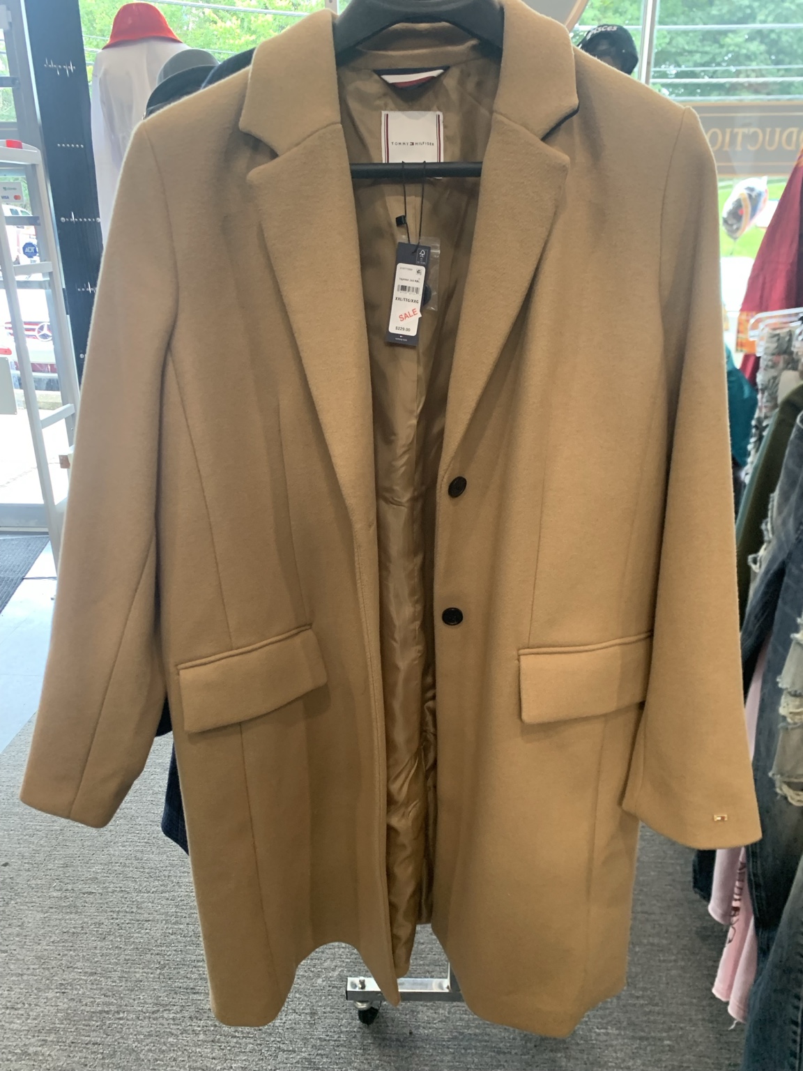 Camel-colored coat with notched lapels, dark buttons, and flap pockets