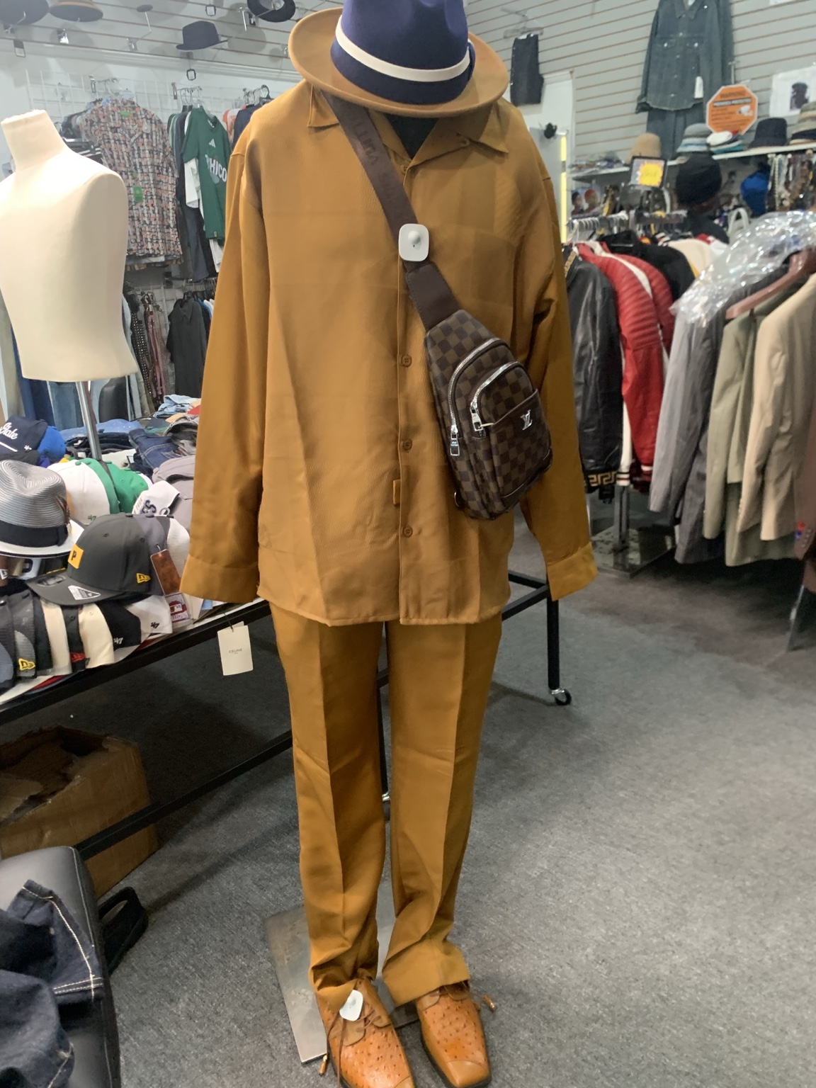 Mustard shirt and matching trousers styled with a two-tone hat, brown crossbody bag, and matching shoes