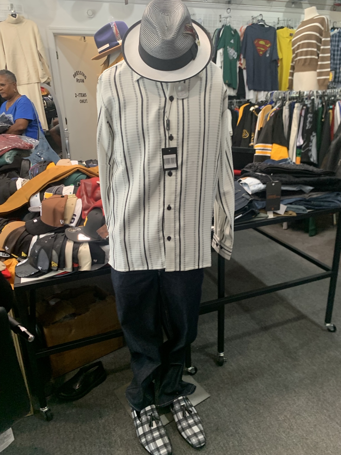 Cream striped shirt with dark trousers, a black-and-white hat, and checked shoes